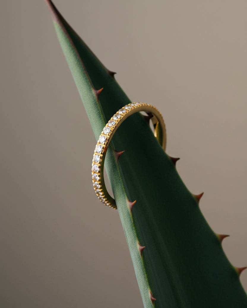 Alianza fina con circonitas pequeñas engastadas, baño de oro amarillo de 18k y estética delicada para uso diario.