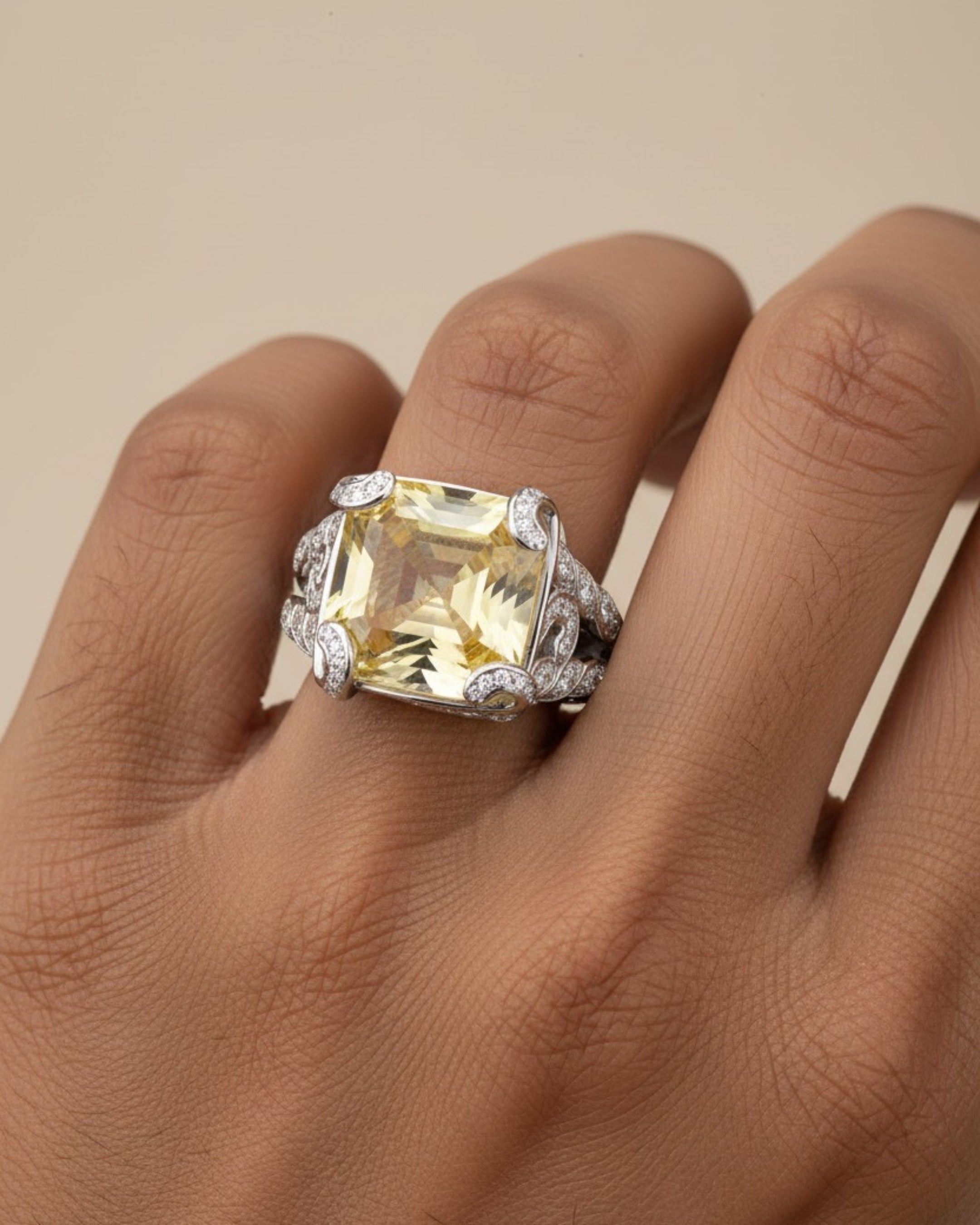 Anillo Bett de diseño elegante con piedra amarilla central y pequeños detalles brillantes que realzan su presencia.