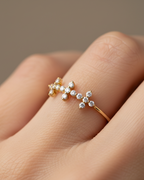 Anillo elegante con circonitas blancas formando cruces, acabado en oro amarillo y estilo sofisticado.