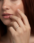 Anillo de diseño fino con tres cruces centrales y circonitas blancas, acabado en oro amarillo de 18 kt.