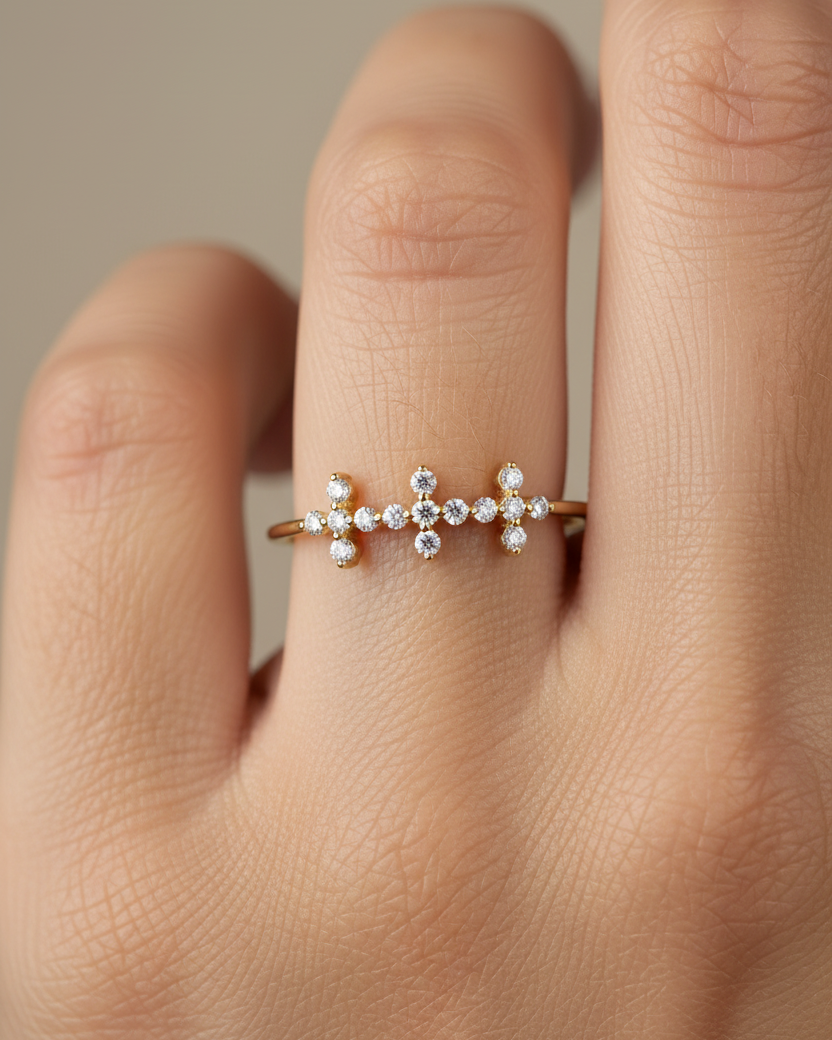 Anillo con tres cruces formadas por circonitas blancas y acabado en oro amarillo de 18 kt, diseño delicado y elegante.