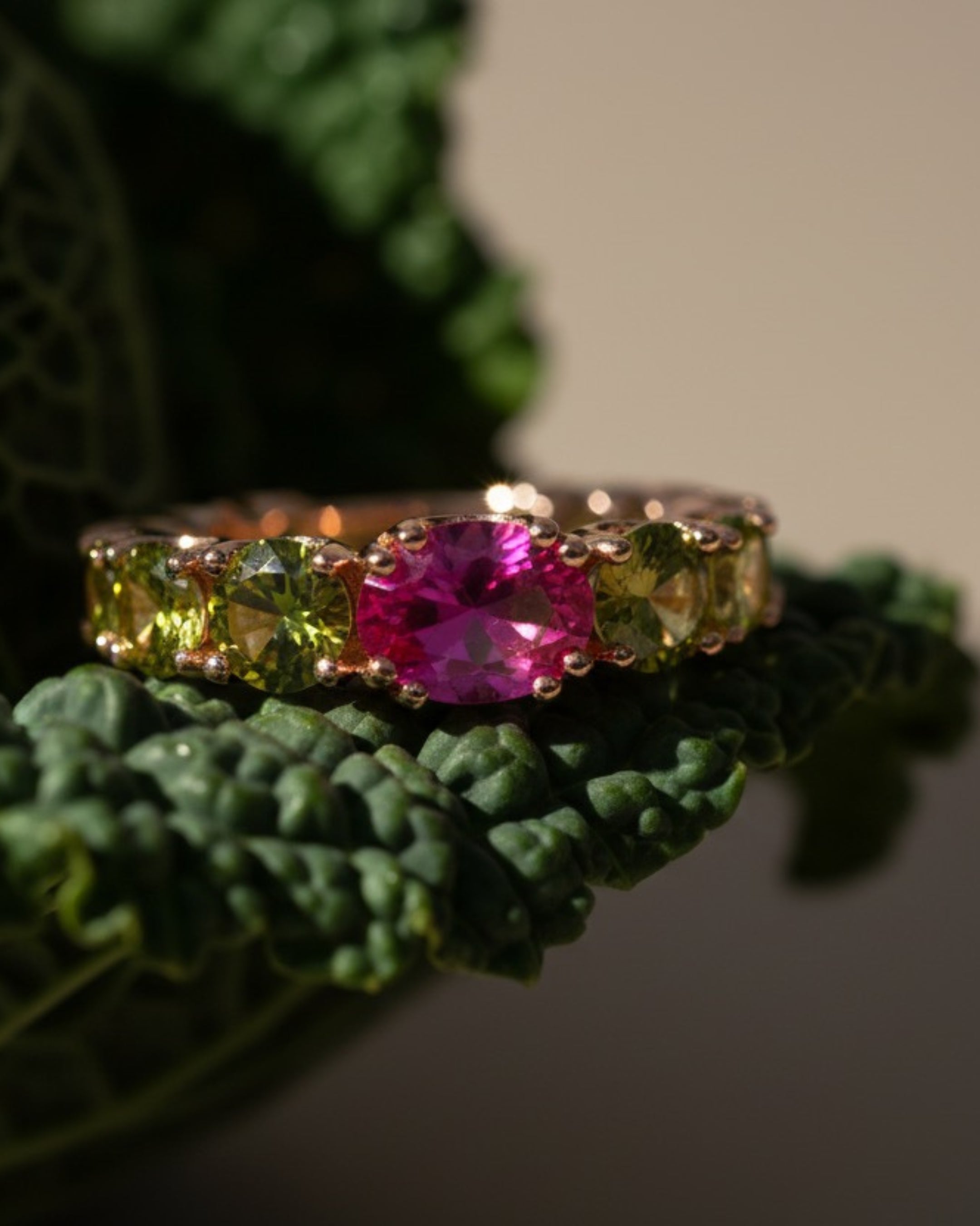 Detalle del anillo Cyca con piedra oval central amatista y piedras circulares en degradado.