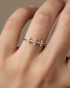 Anillo delicado con diseño de cruces y circonitas en talla circular, acabado en oro amarillo de 18 kt.