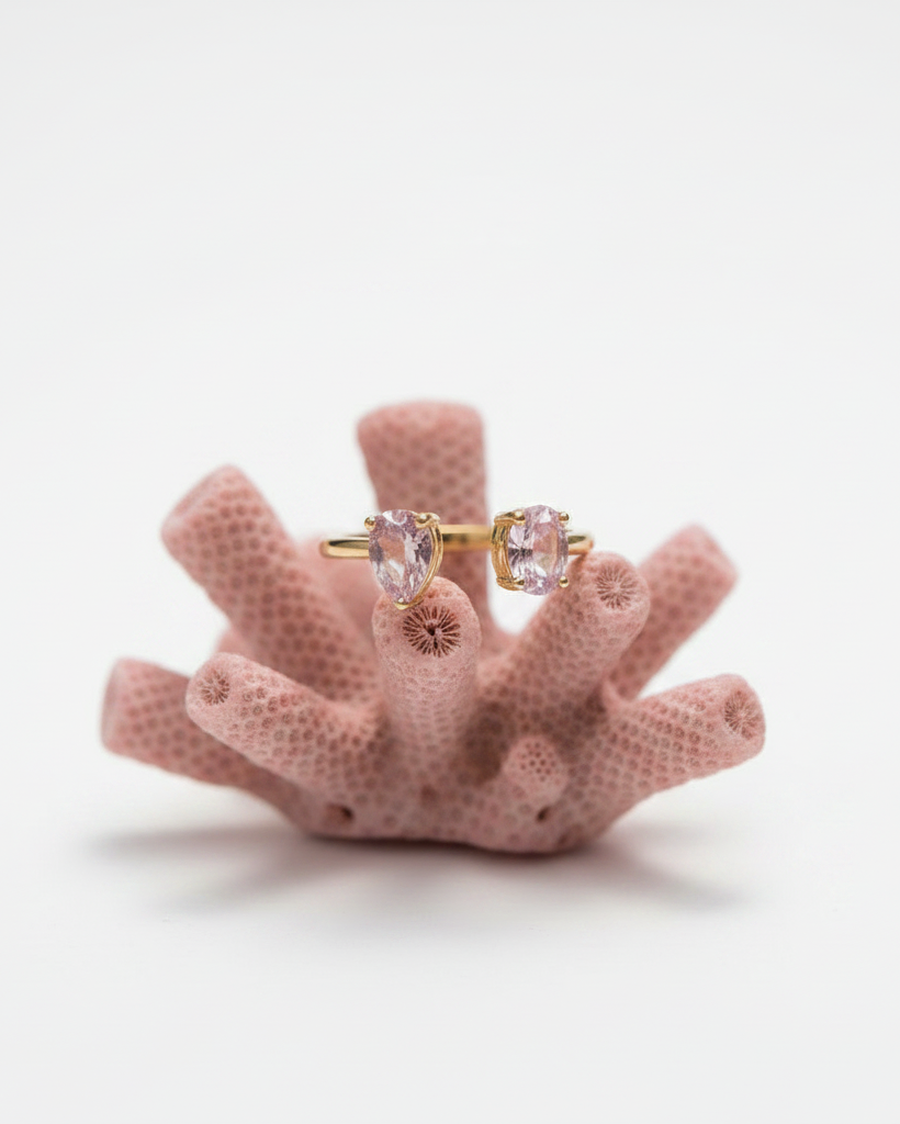Anillo abierto con dos piedras rosas centrales enfrentadas y sin unión.