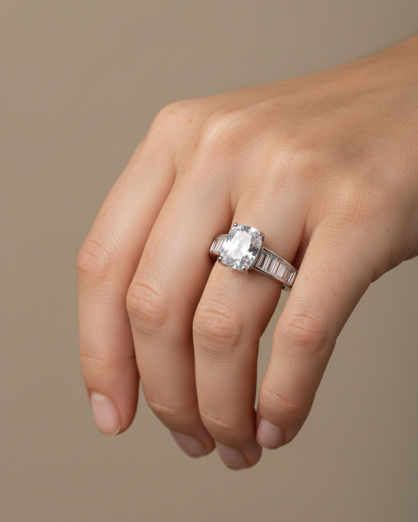 Anillo inspirado en la alta joyería con piedra blanca central y acabado sofisticado.