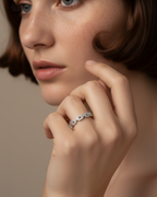Anillo femenino de eslabones entrelazados con delicado brillo blanco.