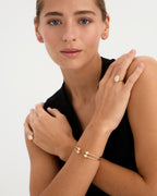 El anillo Flapper, inspirado en las mujeres audaces y libres de los años 20, combina sencillez y sofisticación. Fabricado en plata de ley 925 con un baño de oro amarillo de 18 quilates, este elegante anillo destaca por su piedra ovalada de 10x12 mm, engastada en cuatro garras. Ideal para quienes buscan una pieza con estilo moderno y toques vintage, es perfecto para usar tanto en el dedo meñique como en cualquier ocasión que requiera un toque de distinción