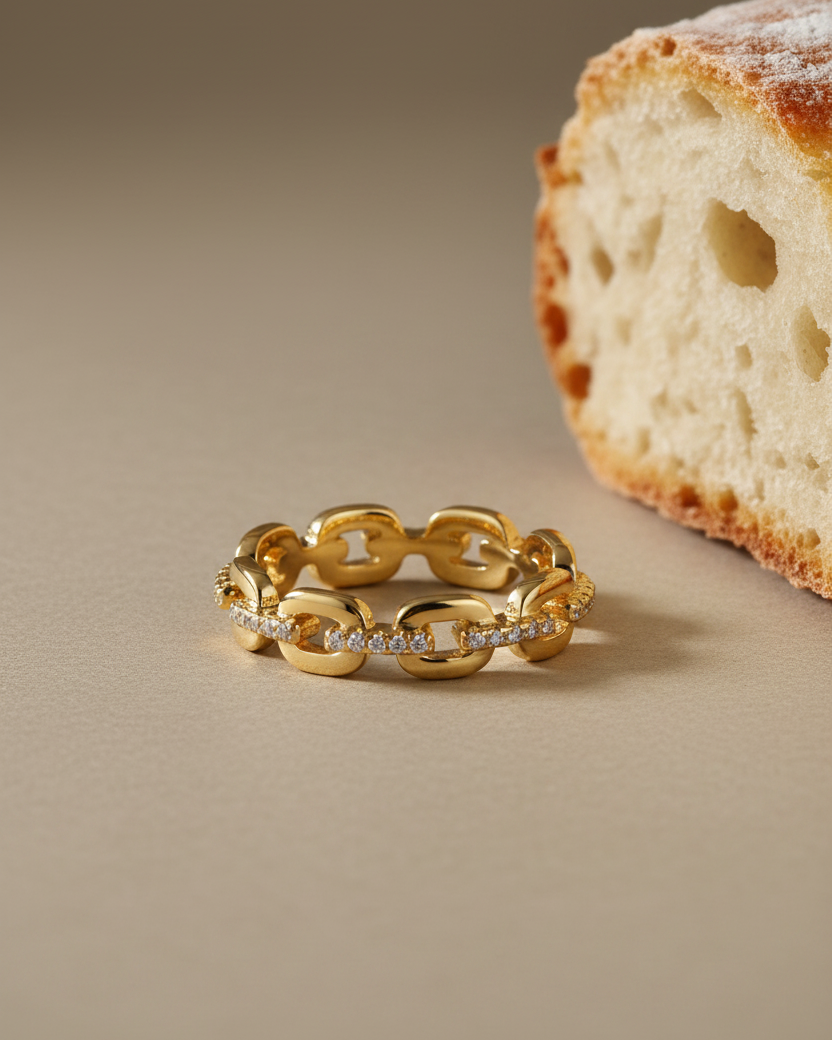 Anillo Jazz con diseño de eslabones y circonitas blancas en talla brillante, acabado en oro amarillo de 18 kt.
