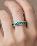 Anillo luminoso con piedras verdes esmeralda y circonitas blancas en un diseño delicado y femenino.