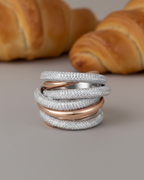 Joya moderna para mujer con múltiples aros y pequeñas circonitas blancas que aportan luz y sofisticación.
