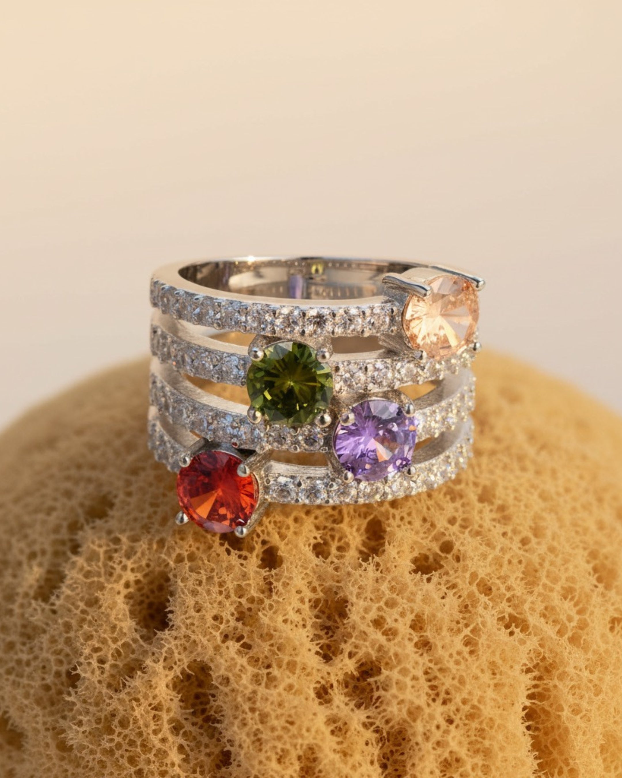 Anillo Persidas con cuatro gemas de colores rodeadas por circonitas brillantes