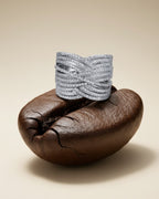 Detalle del relieve cruzado en anillo de plata 925 con piedras blancas.