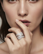 Anillo ROLA de plata 925 con piedras blancas colocado en mano para look elegante.