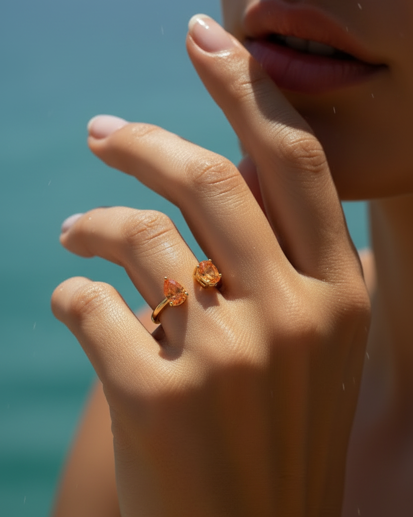 Anillo de plata 925 con piedras en tono naranja intenso y acabado en oro amarillo.
