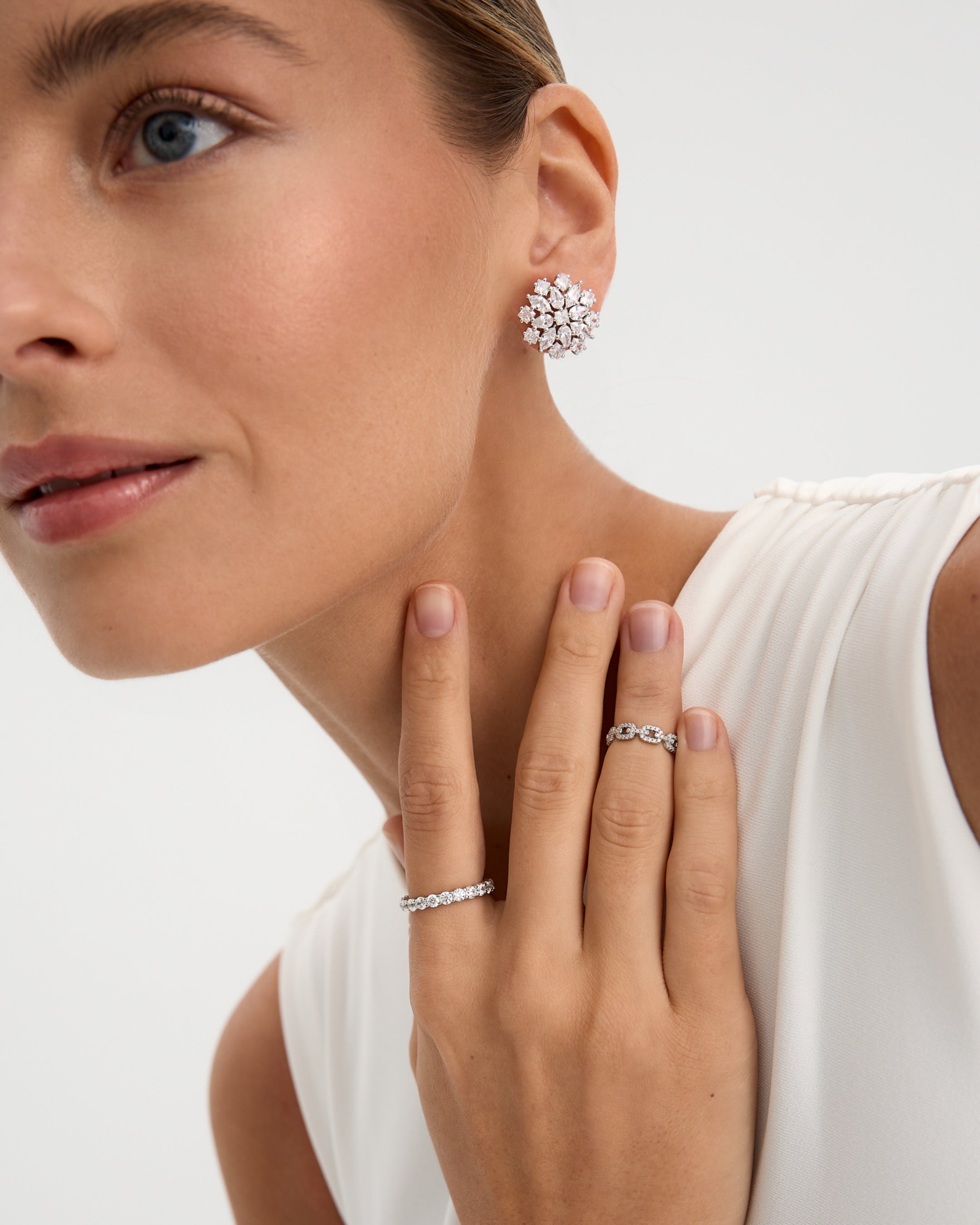 Vista lateral del anillo Tess con chapado en rodio y piedras blancas, una joya versátil y luminosa para todos los días.