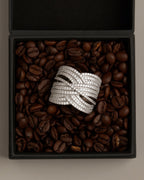 Primer plano de anillo de plata 925 con brillo natural y piedras blancas circulares.