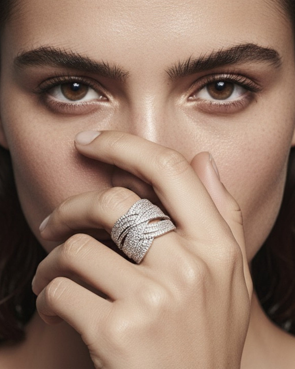 Detalle de anillo de plata 925 con pequeñas piedras blancas y diseño elegante cruzado.