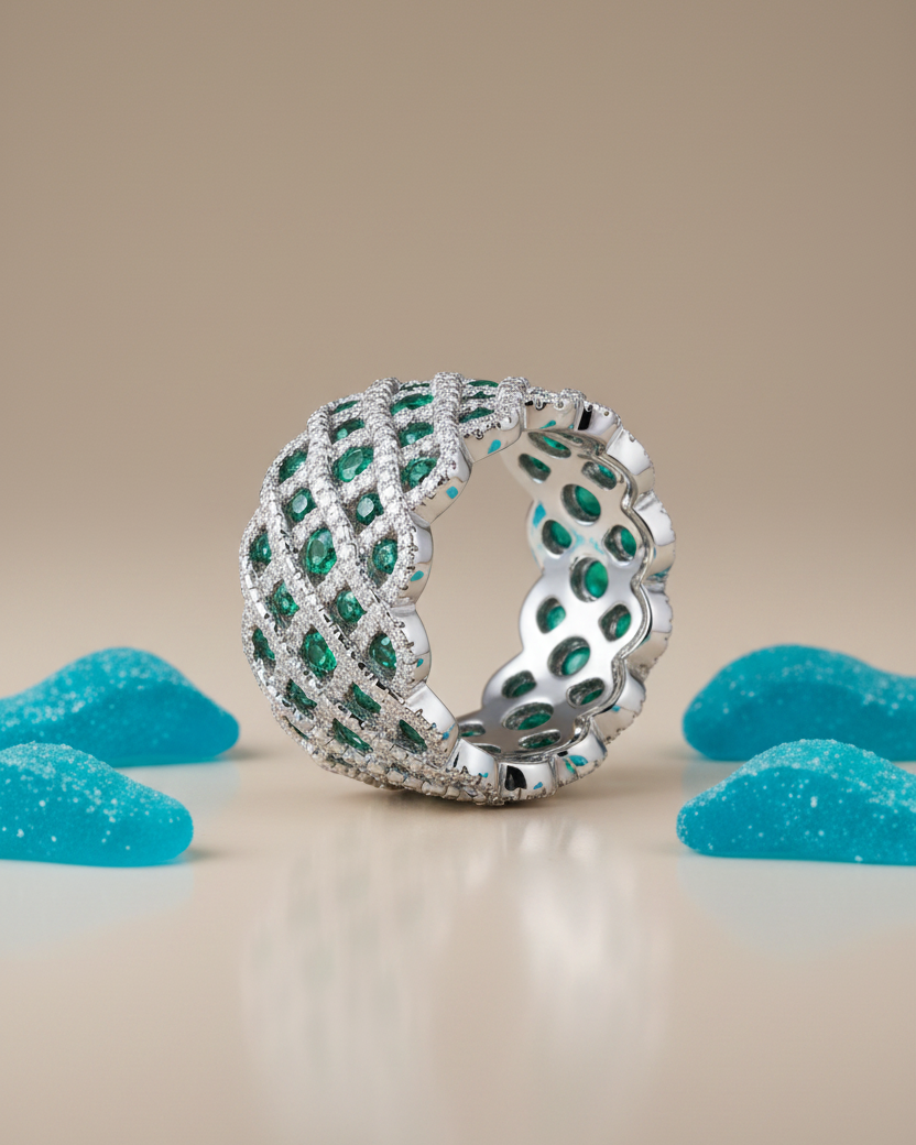 Detalles del anillo STILL con contraste luminoso de piedras blancas y verdes esmeralda.