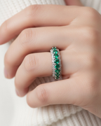 Anillo delicado TRUE en rodio blanco con piedras verdes esmeralda de 3 mm y circonitas blancas de 1,25 mm. Una pieza ligera y elegante que combina sencillez y sofisticación, ideal para llevar sola o combinada con otros anillos.