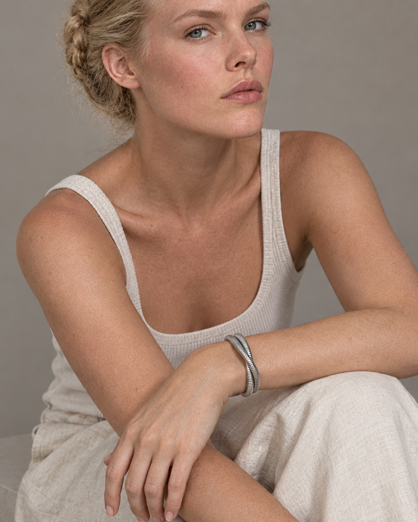 Brazalete LUCE blanco con superficie texturizada y diseño tubular de líneas limpias.