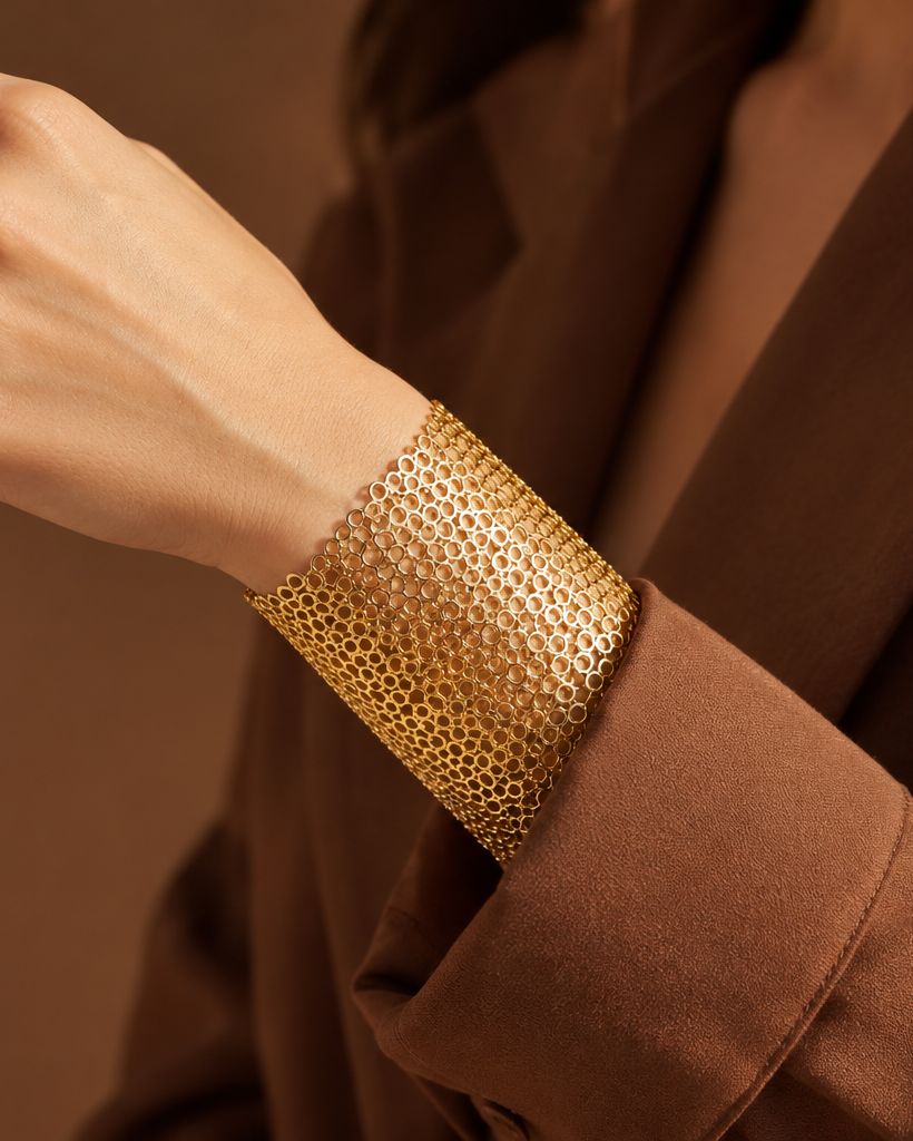 Brazalete ZARB dorado y ajustable con estructura abierta de círculos entrelazados.