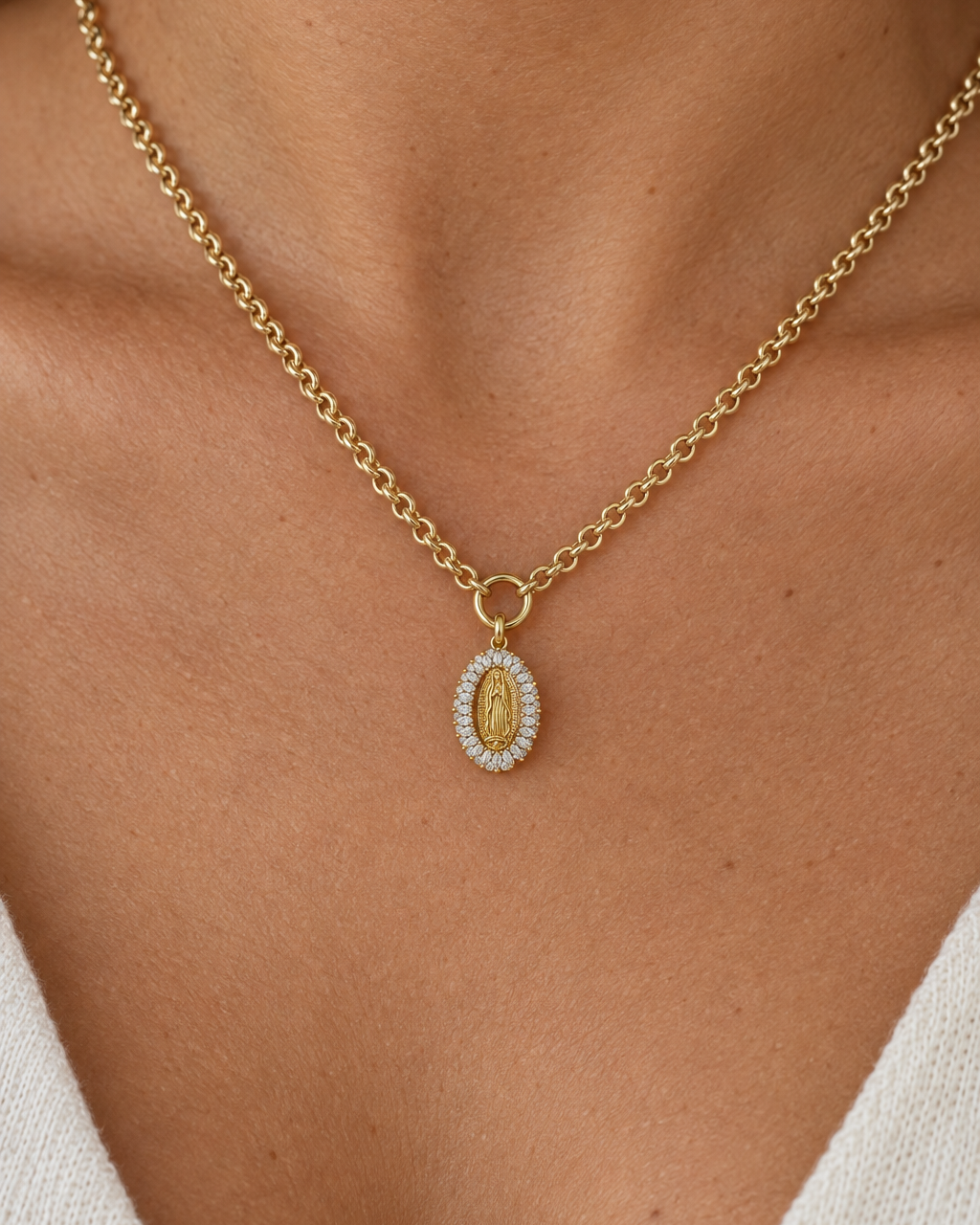 Colgante VIT con figura de la Virgen en relieve y halo de circonitas transparentes.
