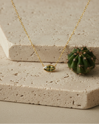 Collar con cadena fina y piedra verde central en talla marquesa, acabado en oro amarillo de 18 kt.