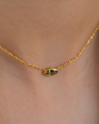 Collar de diseño fino con piedra verde en talla marquesa, acabado en oro amarillo de 18 kt y estilo versátil.