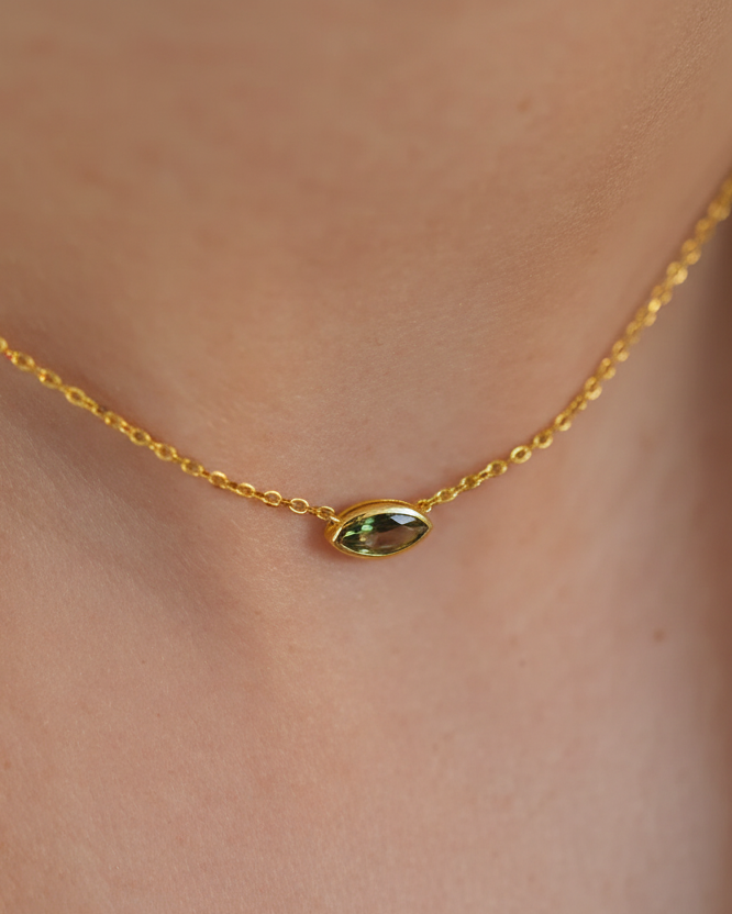 Collar de diseño fino con piedra verde en talla marquesa, acabado en oro amarillo de 18 kt y estilo versátil.