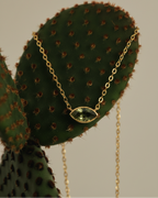 Collar elegante con piedra verde en talla marquesa y acabado en oro amarillo de 18 kt, diseño fino y femenino.