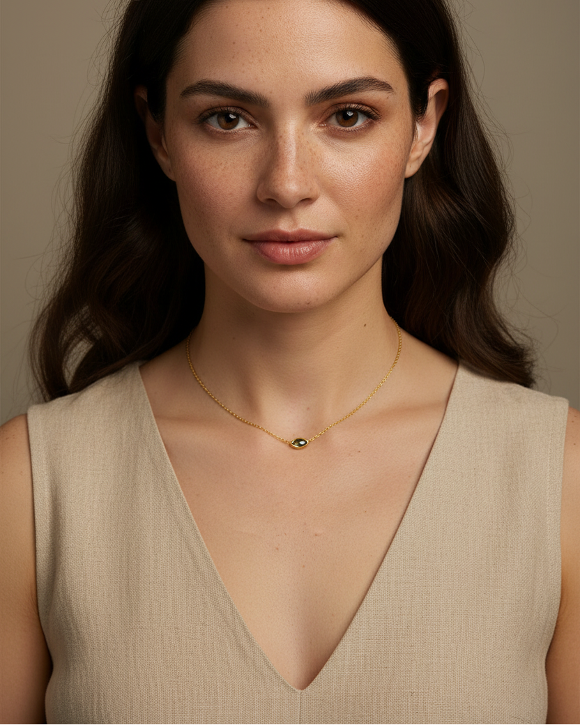 Collar con circonita verde en talla marquesa y acabado en oro amarillo, ideal para un look elegante y actual.