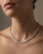 Collar joya con acabado en rodio y piedras brillantes que reflejan la luz con elegancia.