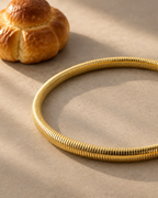 Collar SERA dorado con volumen tubular y acabado texturizado de inspiración contemporánea.
