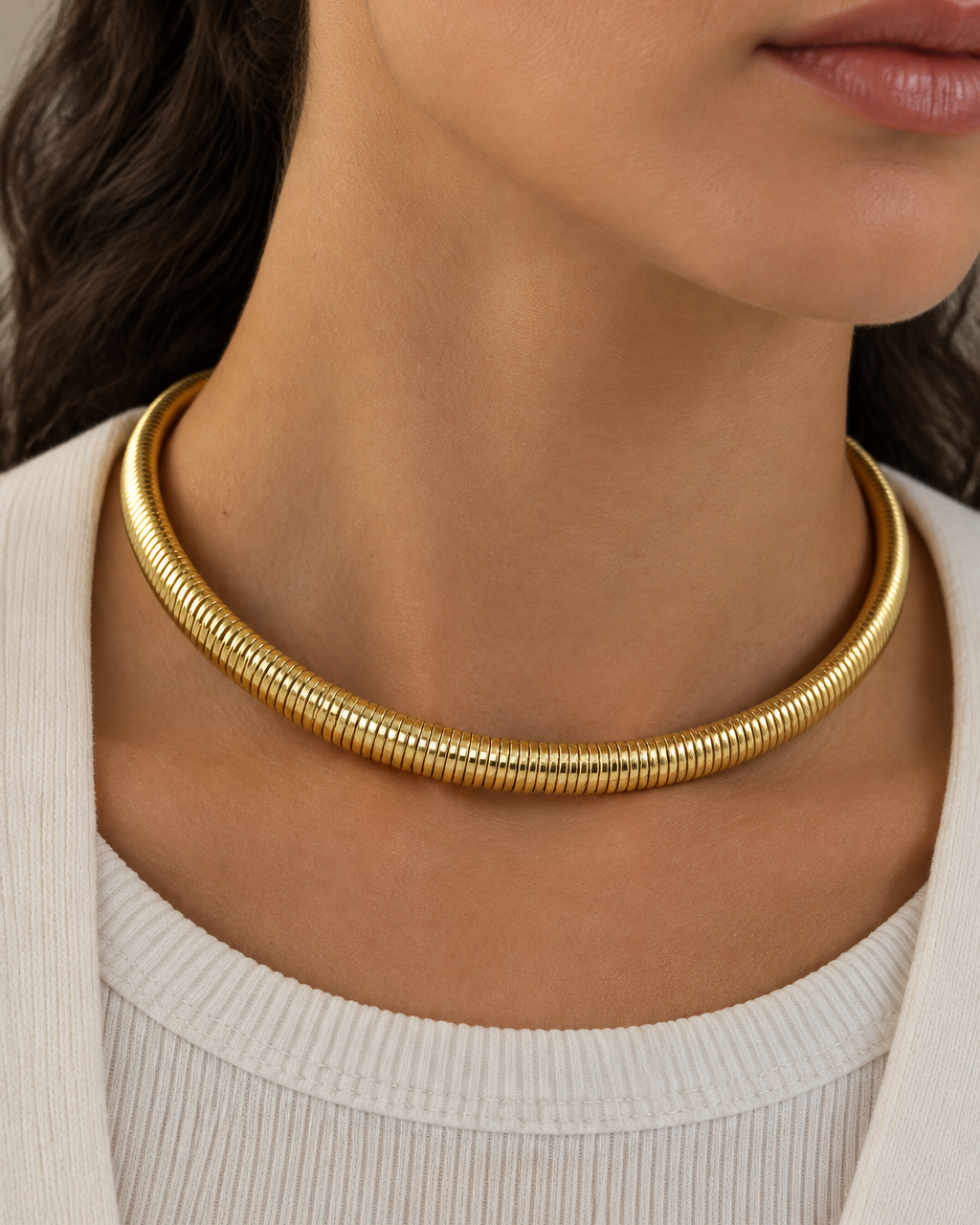 Collar SERA tipo gargantilla tubular con acabado dorado y cierre posterior.