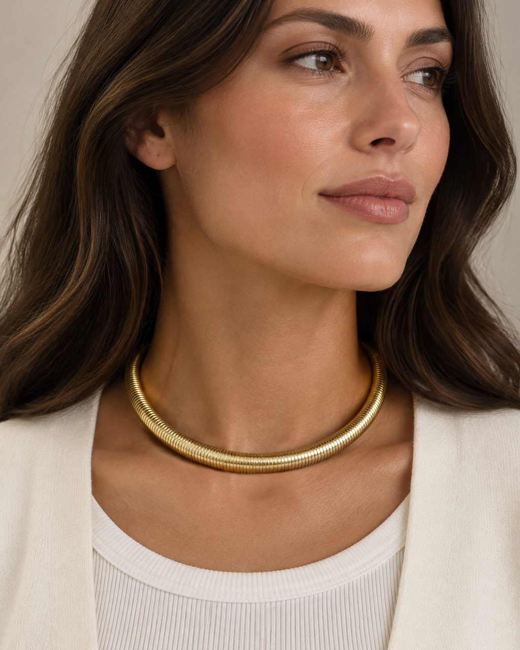 Collar tubular SERA con acabado dorado y relieve acanalado en toda la superficie.