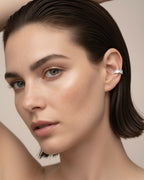 Ear cuff Alba en rodio blanco con piedras blancas en talla baguette y circular. Un diseño brillante y elegante que aporta luz y sofisticación a cualquier look.