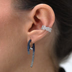 Ear cuff Alba con acabado en rodio blanco y piedras blancas en talla baguette y brillante. Una pieza sofisticada y moderna ideal para looks elegantes.