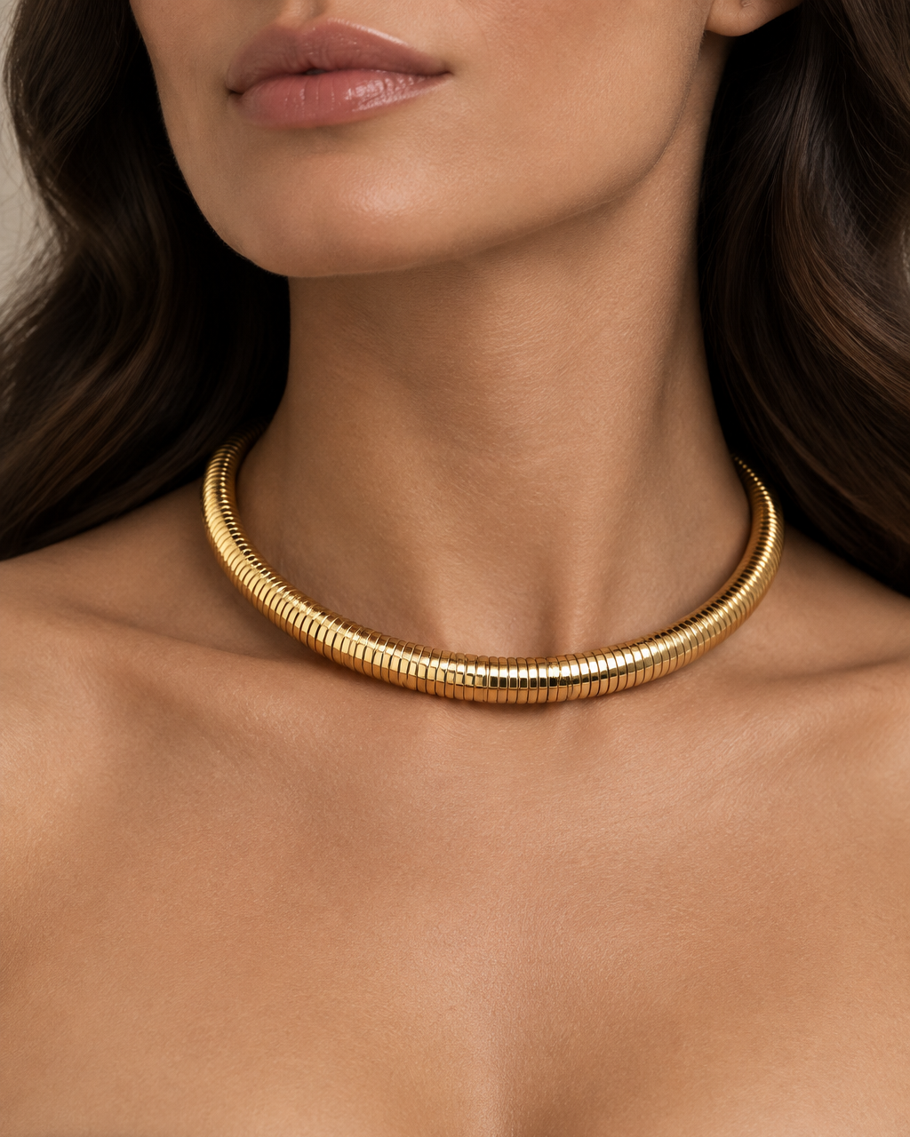 Gargantilla dorada SERA con relieve acanalado y silueta redondeada alrededor del cuello.