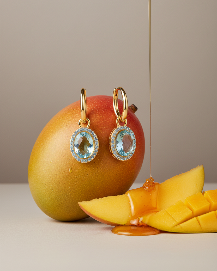 Pendientes de aro dorado con piedra azul ovalada y circonitas brillantes azul topacio.