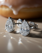 Pendientes blancos refinados con piedra talla pera y brillo sofisticado.