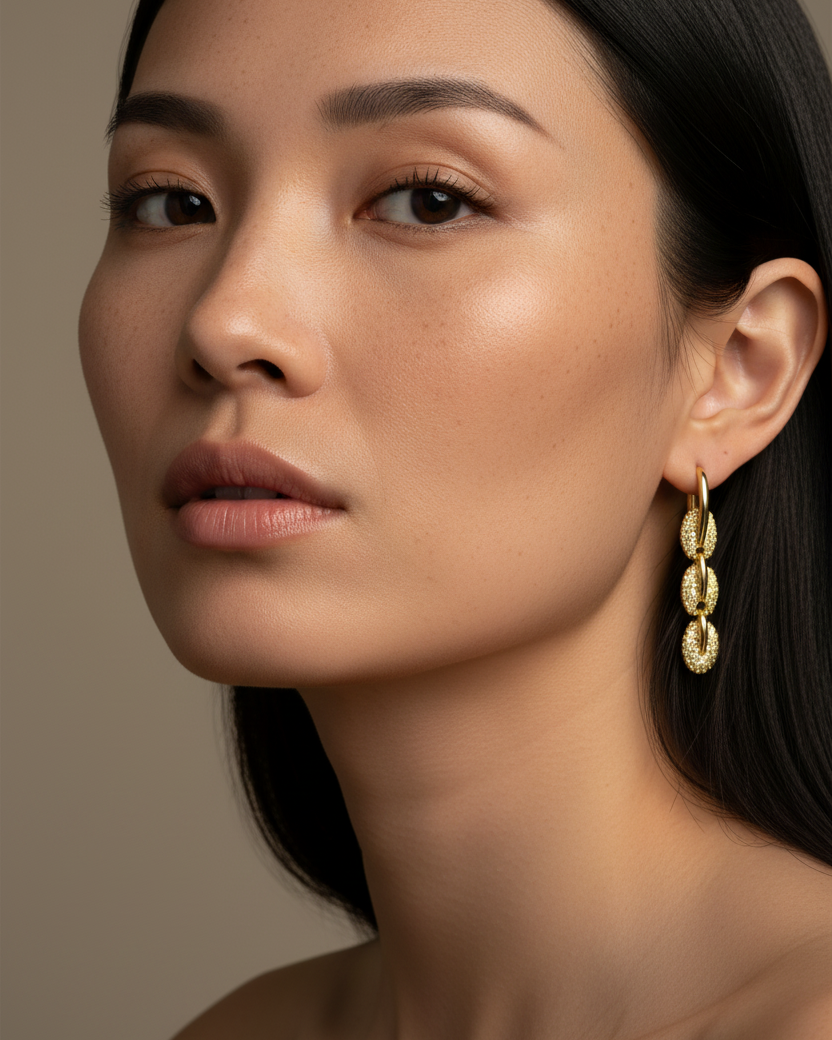 Pendientes de cadena dorados con piedras brillantes y estilo contemporáneo inspirado en la tendencia industrial.