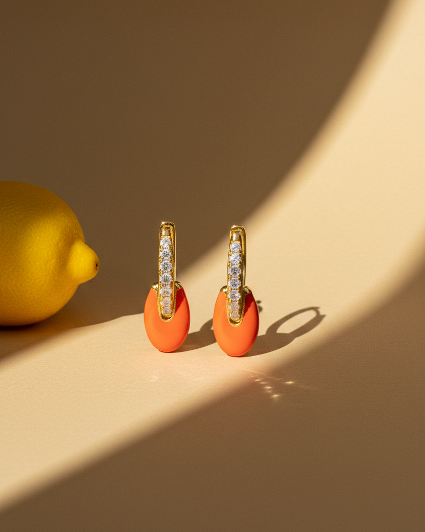 Pendientes color coral con acabado dorado y estilo delicado y contemporáneo.