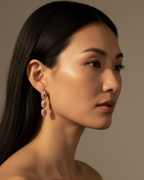 Pendientes Coralina con brillo rosa y acabado dorado, ideales para elevar cualquier look.