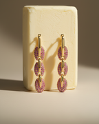 Pendientes Coralina con glamour moderno, piedras rosas y acabado en oro amarillo.