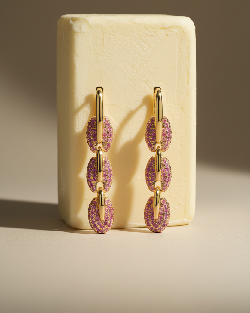 Pendientes Coralina con glamour moderno, piedras rosas y acabado en oro amarillo.