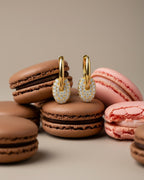 Detalle de pendientes con piedras blancas que aportan luz y contraste al diseño.