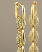 Pendientes dorados de cadena con piedras brillantes y estilo elegante y femenino.