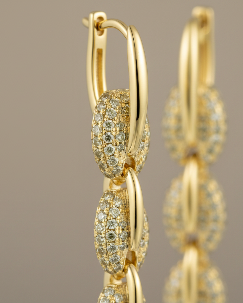 Pendientes dorados de cadena con piedras brillantes y estilo elegante y femenino.