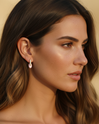Pendientes dorados con esmalte rosa y estilo femenino y sofisticado.