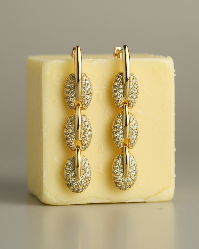 Pendientes dorados con piedras brillantes y diseño femenino y contemporáneo.